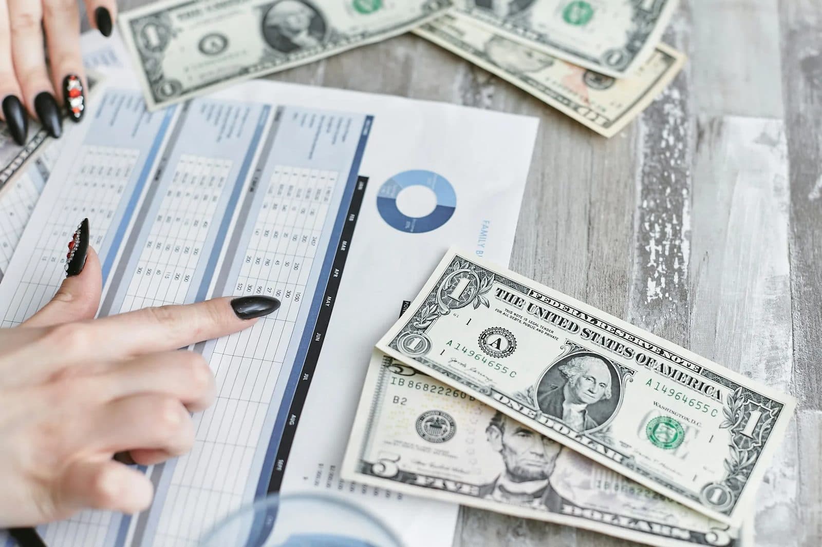 A business owner reviewing a paper ledger and cash at a desk